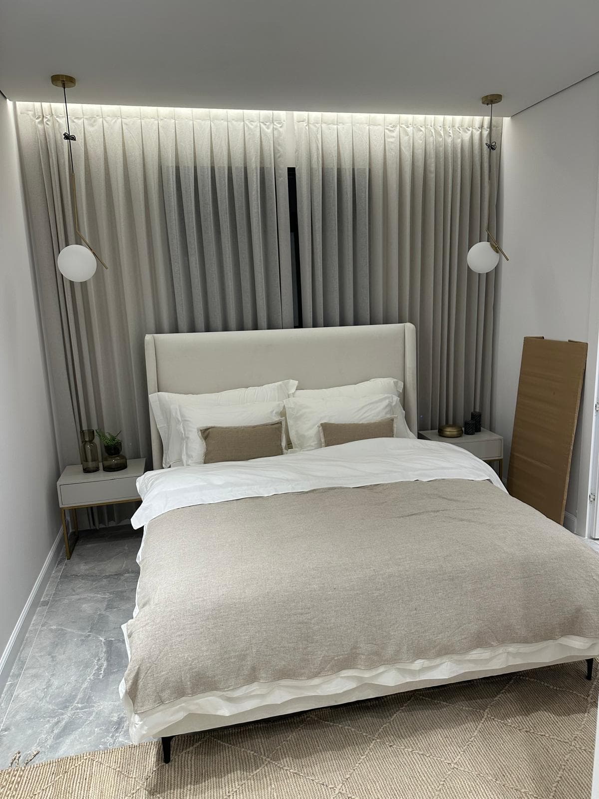 Serene bedroom with floor-to-ceiling drapery and cove lighting