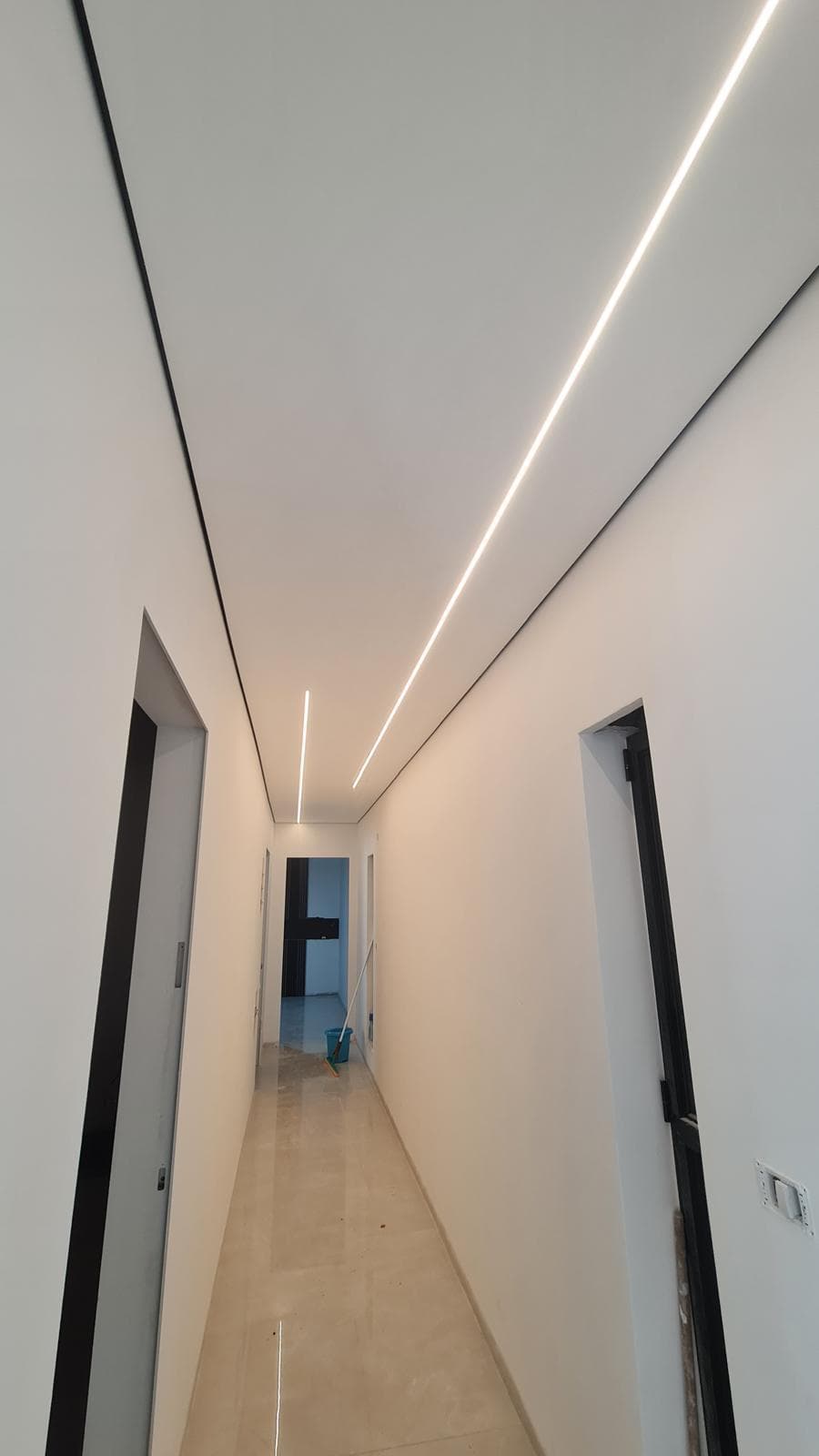 Sleek hallway with recessed linear LED lighting and crisp painted drywall